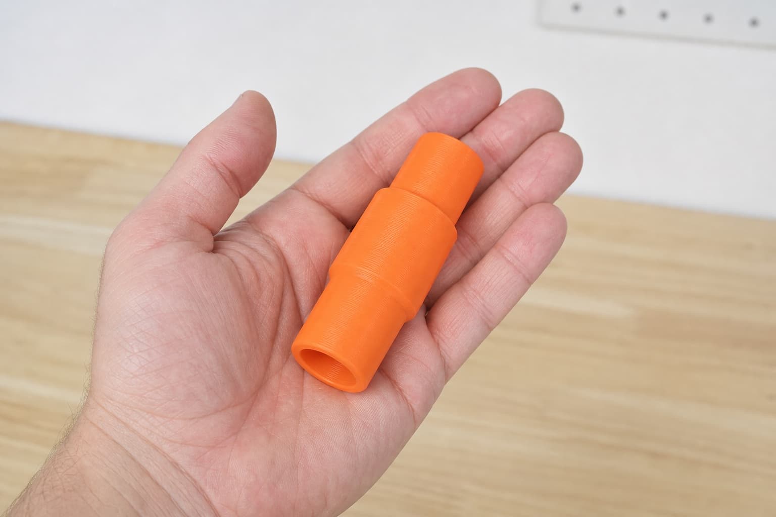The 9404 to 27mm Festool dust adapter held in one hand to show its size