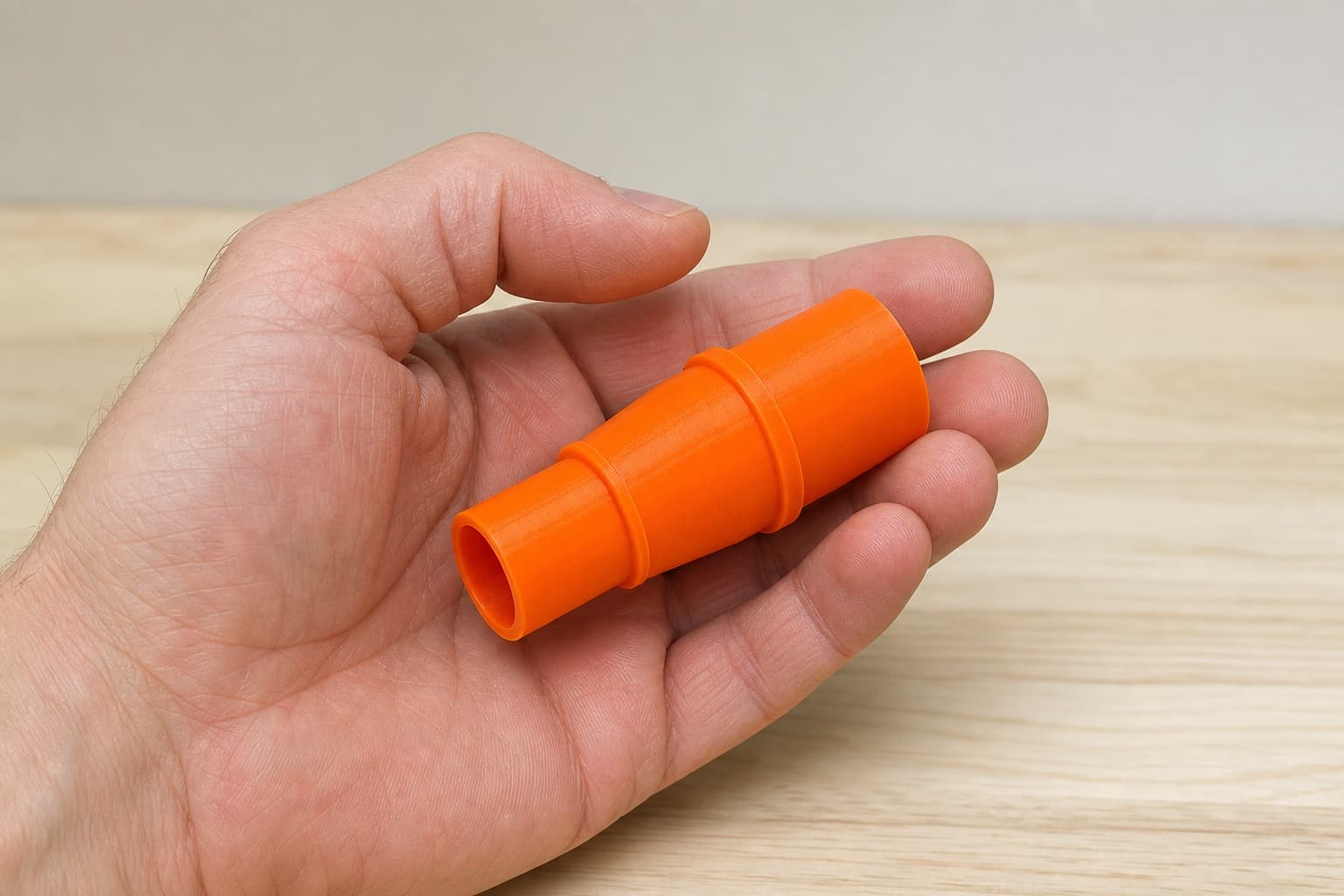 The 9404 to 1.25" Duct dust adapter held in one hand to show its size
