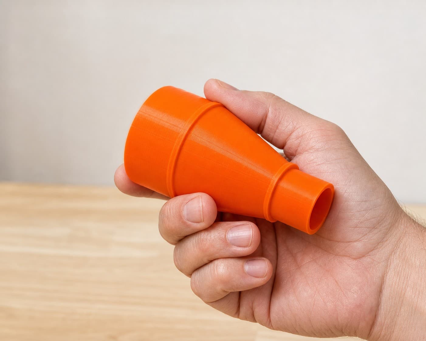 The 9404 to Craftsman 20G dust adapter held in one hand to show its size