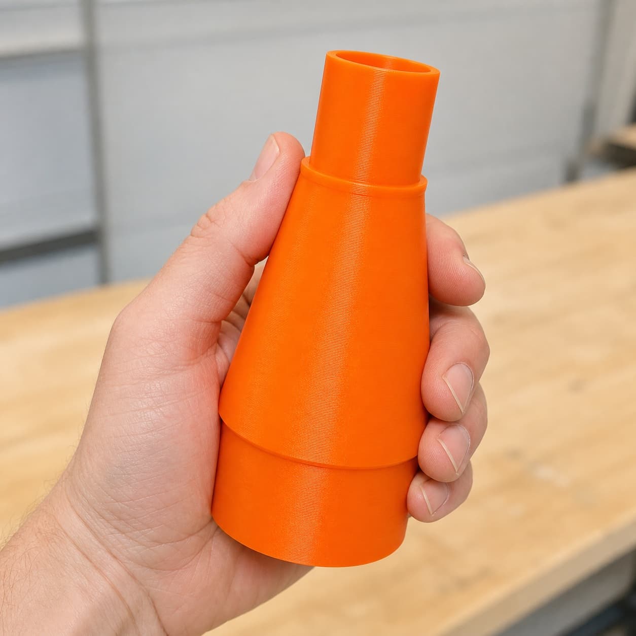 The 9404 to Bauer 6G Vac dust adapter held in one hand to show its size
