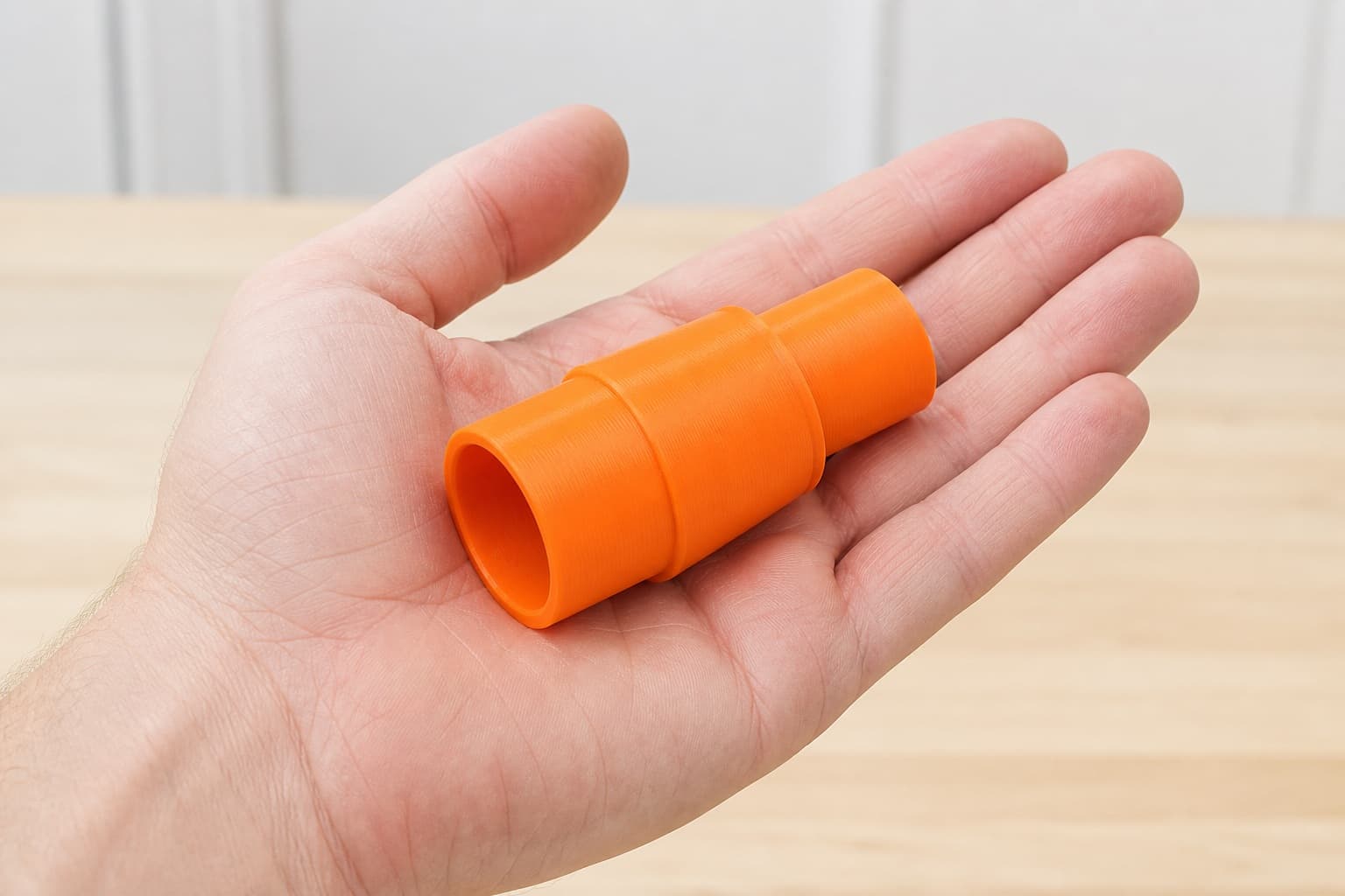 The KS120 to Bosch GAS18V-10L dust adapter held in one hand to show its size