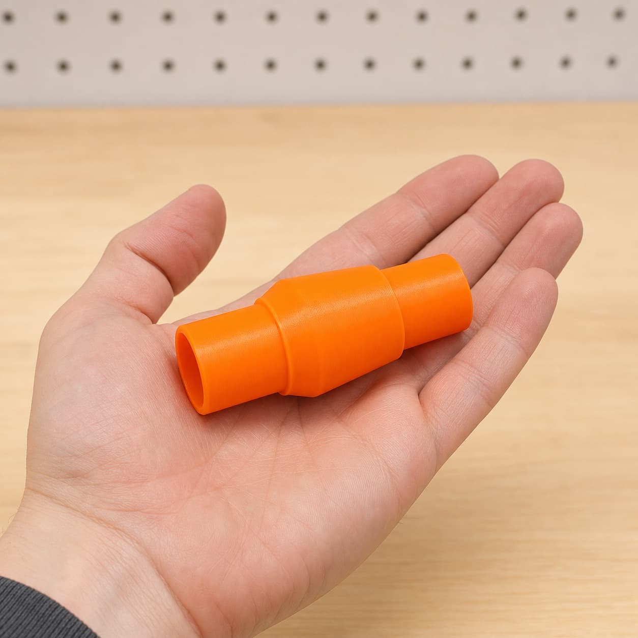 The Origin to 36mm Festool dust adapter held in one hand to show its size