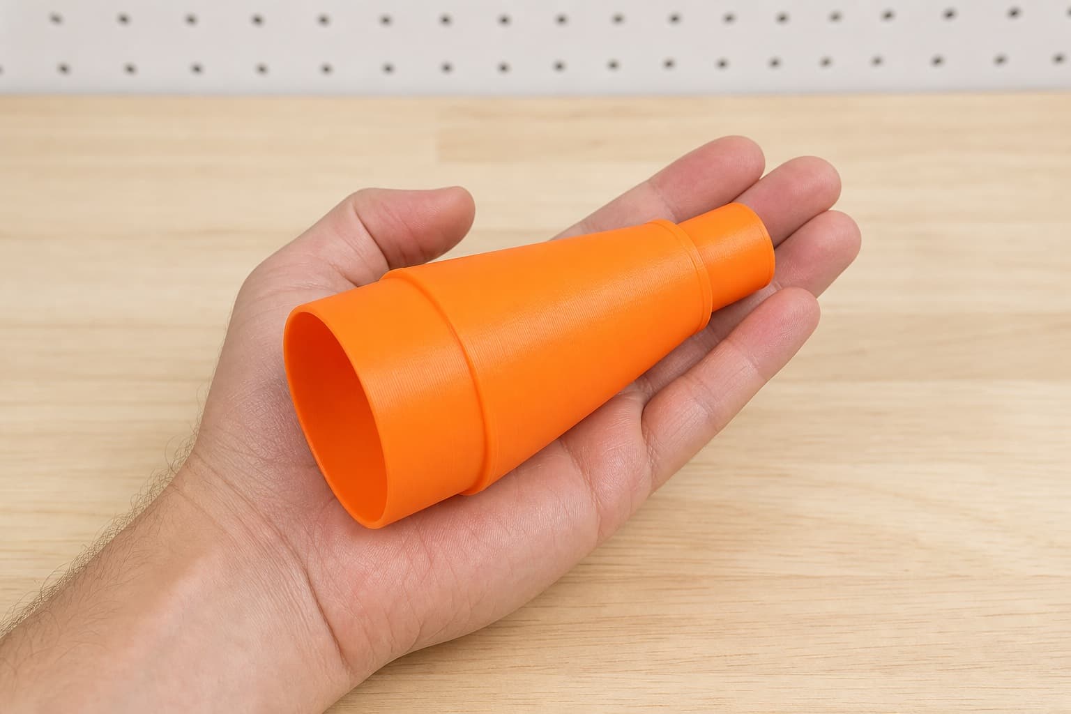 The 574174 to 2.25" Duct dust adapter held in one hand to show its size