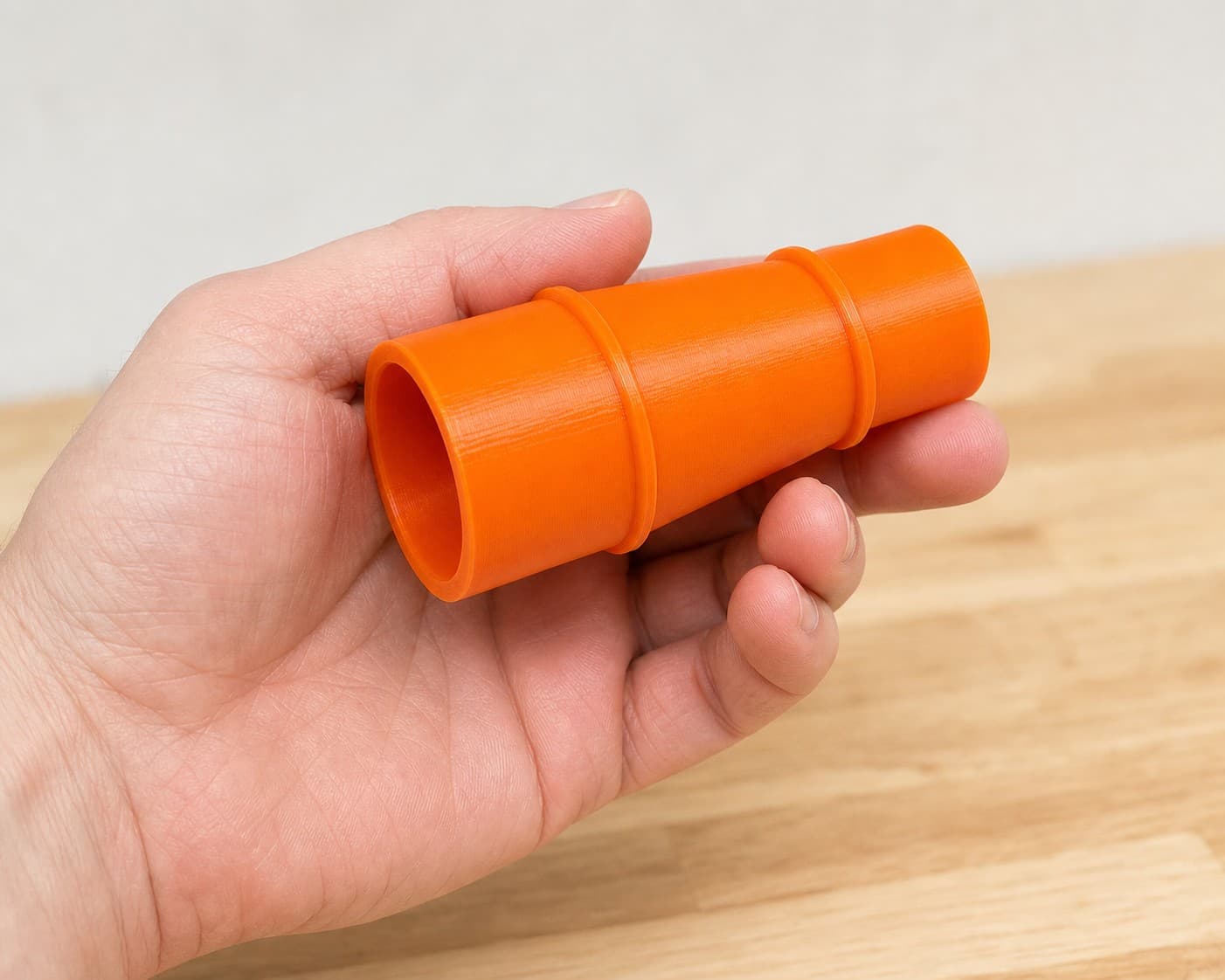 The CMCS550B to 1" Duct dust adapter held in one hand to show its size