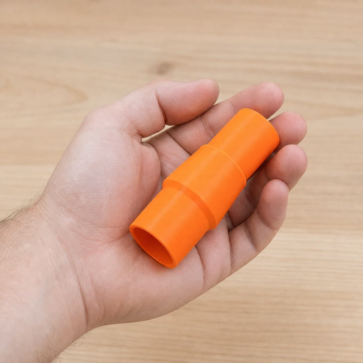 The 2731-20 to Festool CT MINI dust adapter held in one hand to show its size