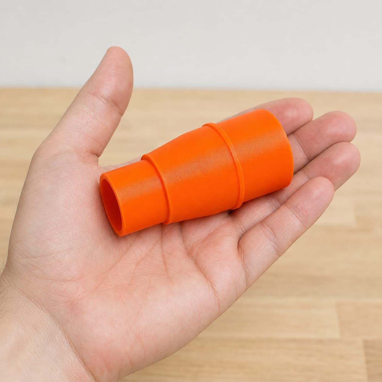 The DCS334B to 1.5" Duct dust adapter held in one hand to show its size
