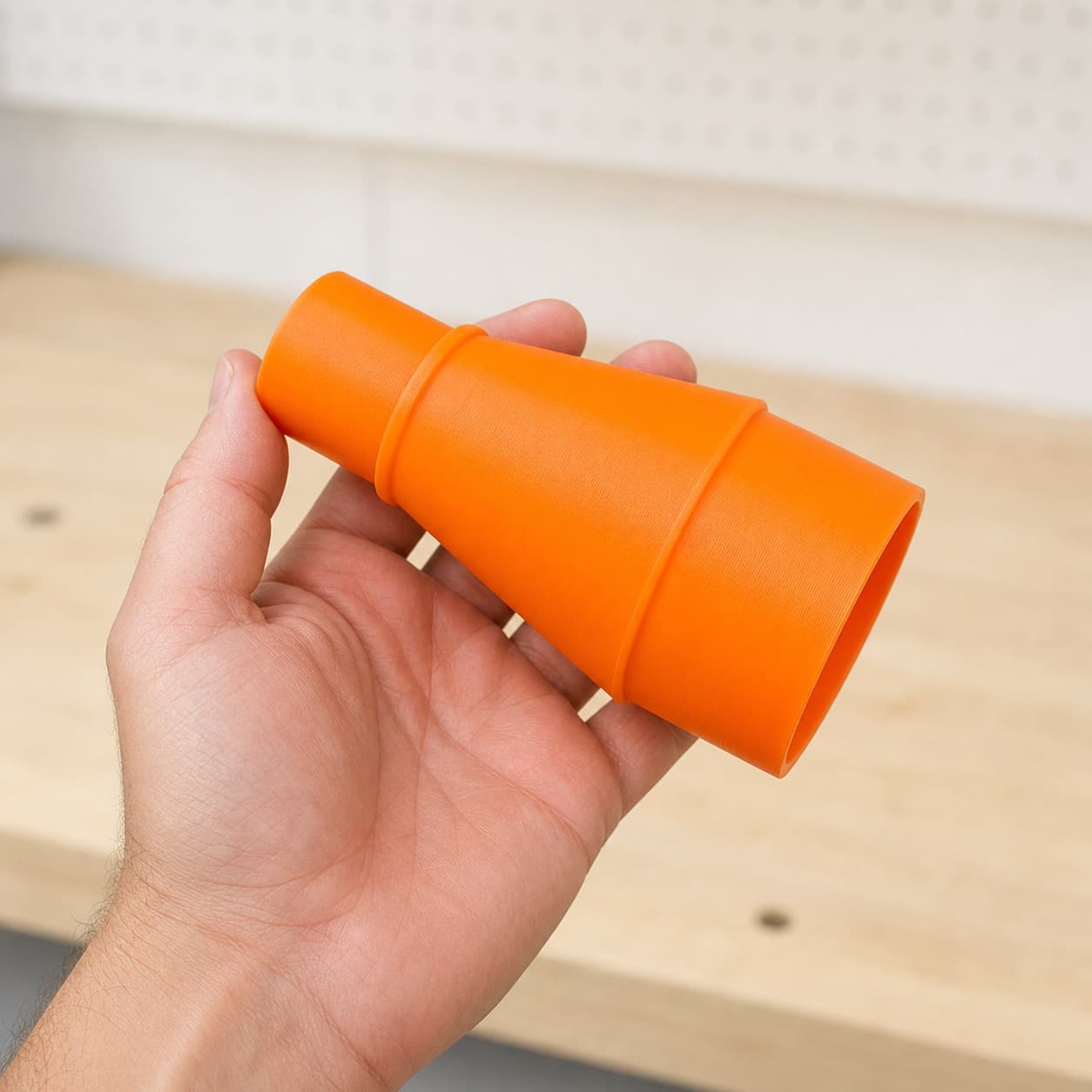 The R8652 to Craftsman 16G dust adapter held in one hand to show its size
