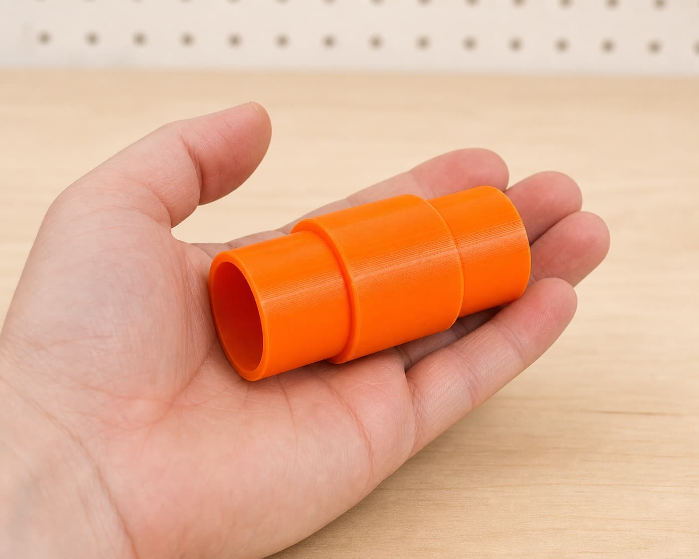 The DRT50 to 1.25" Duct dust adapter held in one hand to show its size