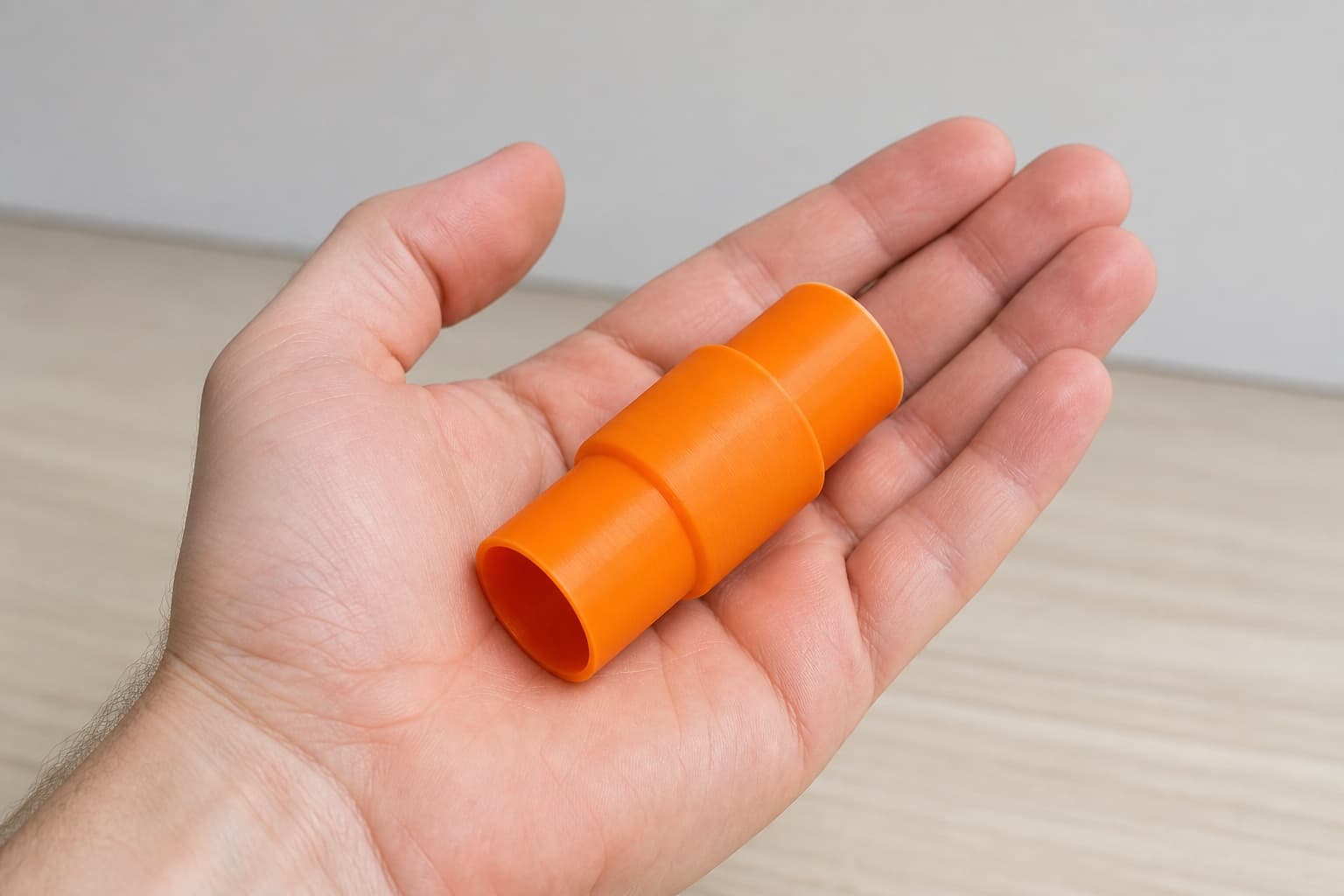 The RP2303FC to DeWalt DWV010 dust adapter held in one hand to show its size