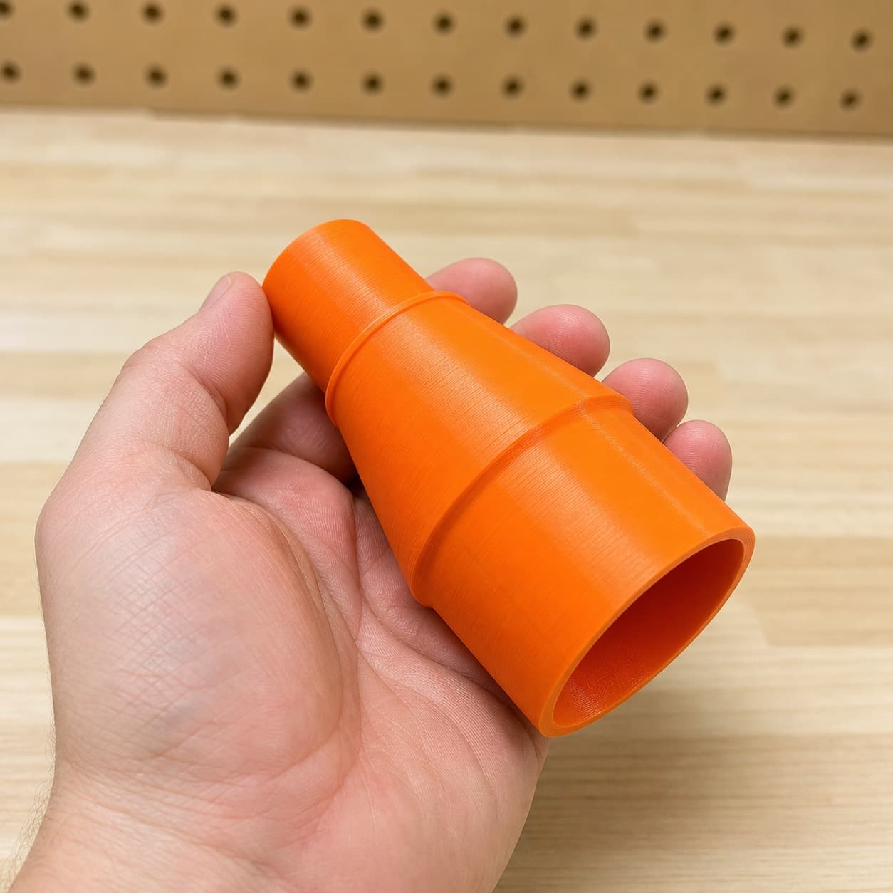 The DRT50 to M18 6G Vac dust adapter held in one hand to show its size