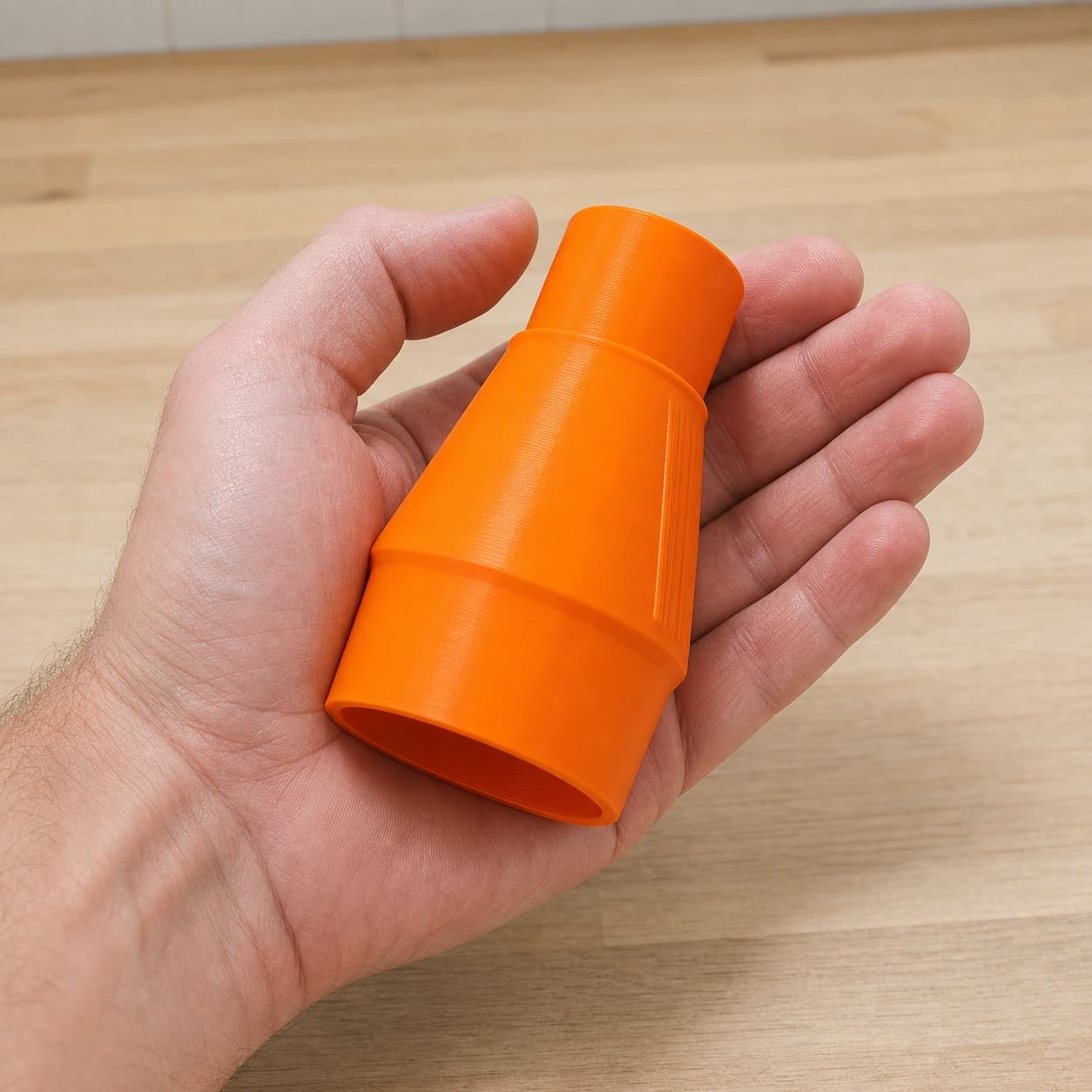 The DWS682K to Bauer 6G Vac dust adapter held in one hand to show its size