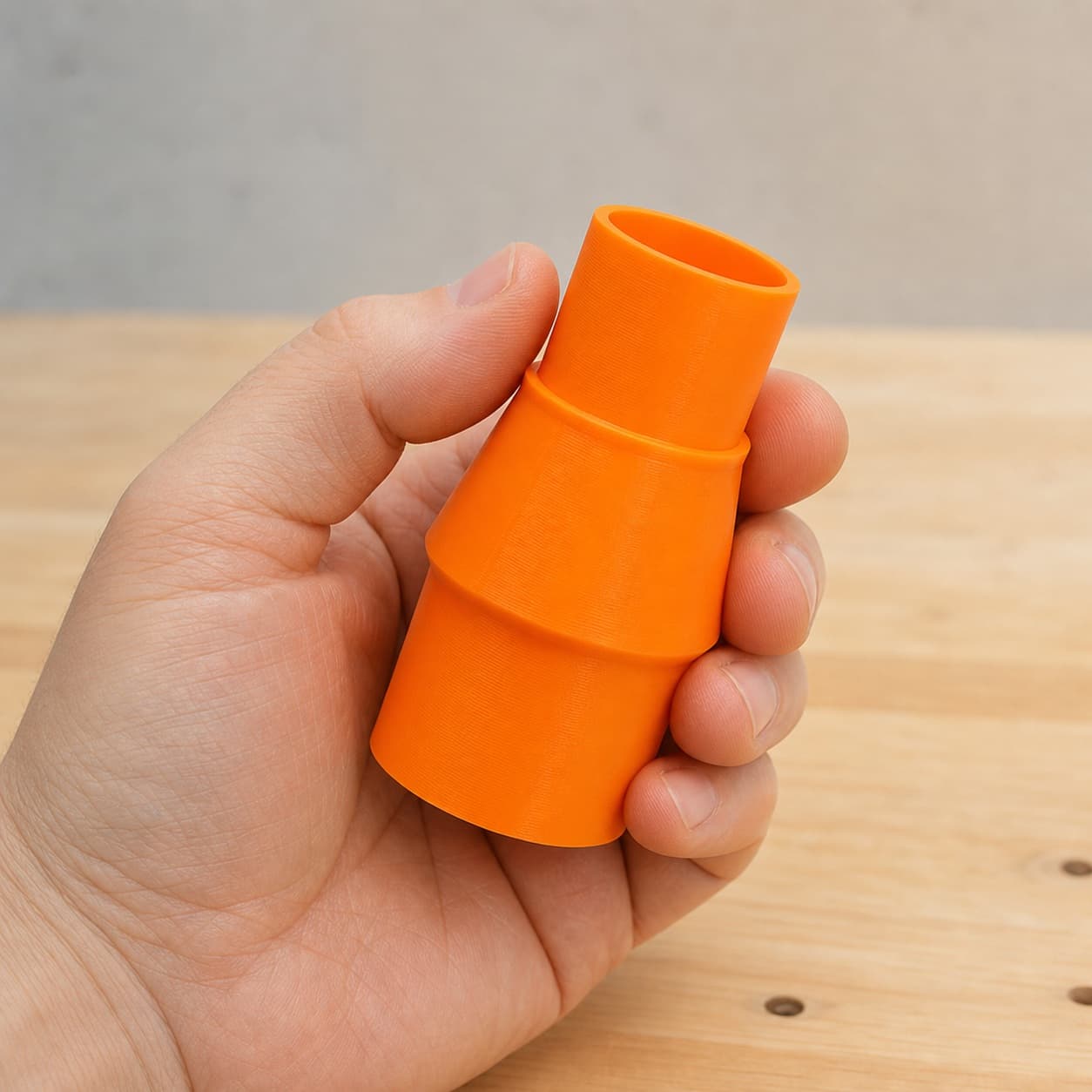 The DWS713 to M18 6G Vac dust adapter held in one hand to show its size