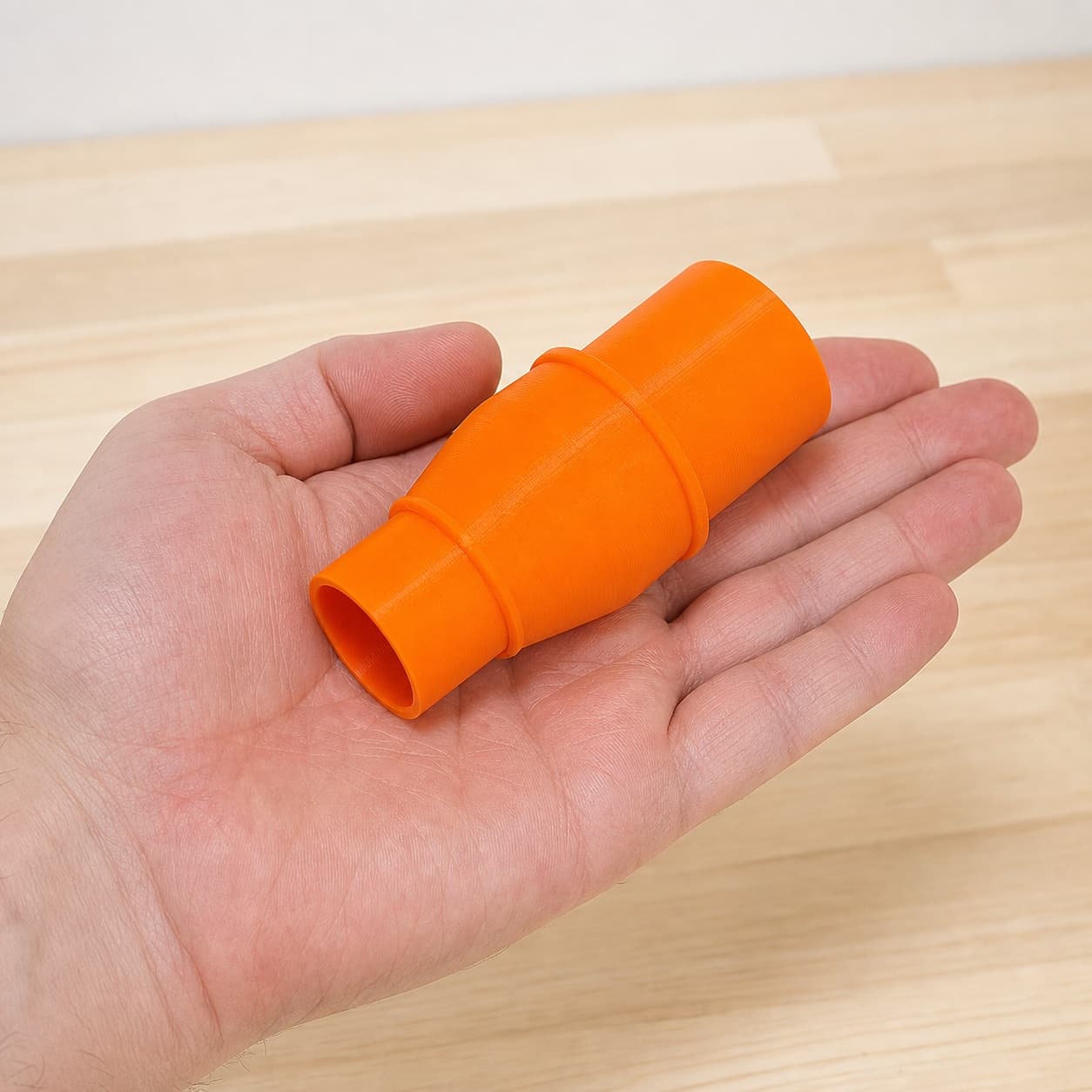 The MultiMaster to 1" Duct dust adapter held in one hand to show its size