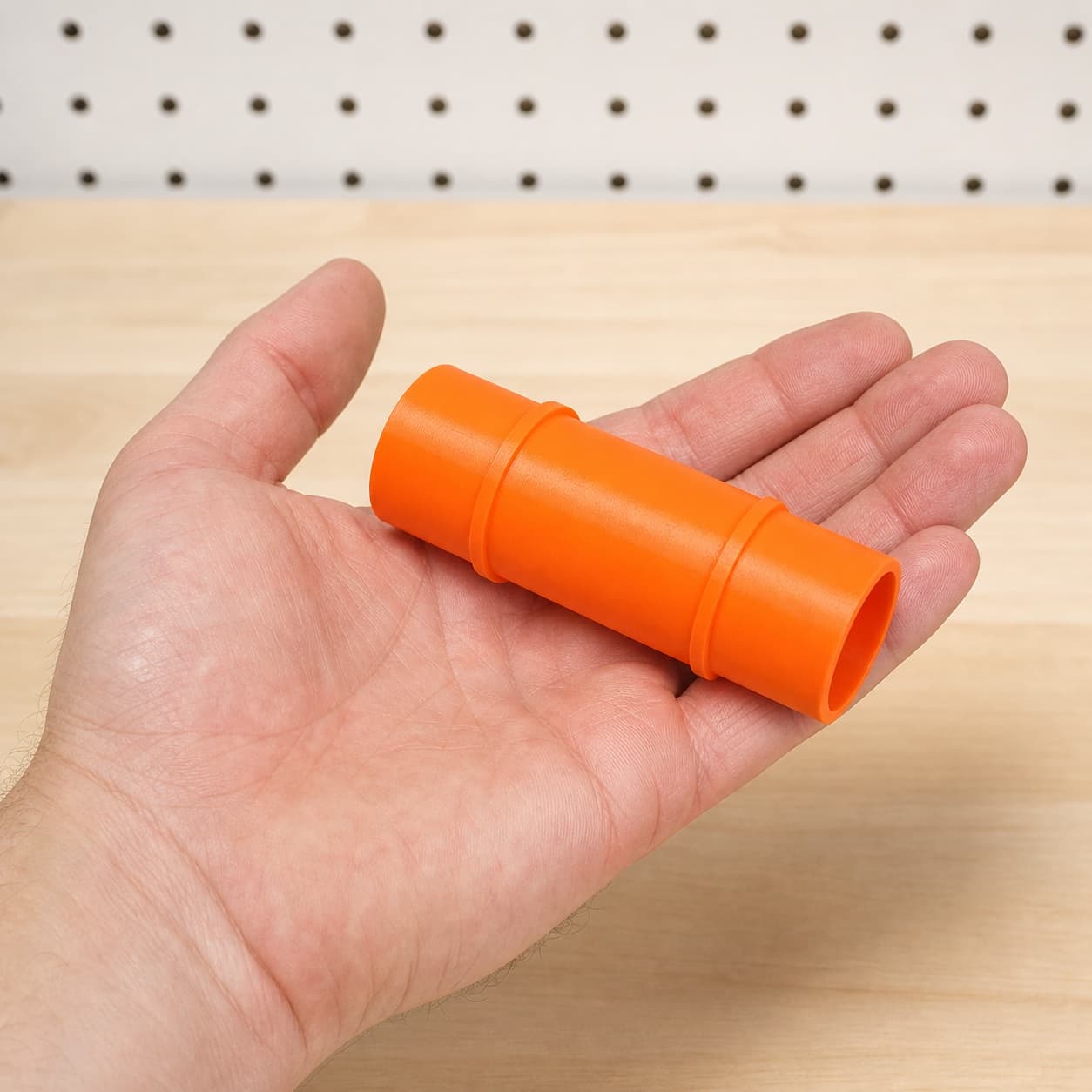 The SCT 60-22 to Makita XCV11Z 2G dust adapter held in one hand to show its size