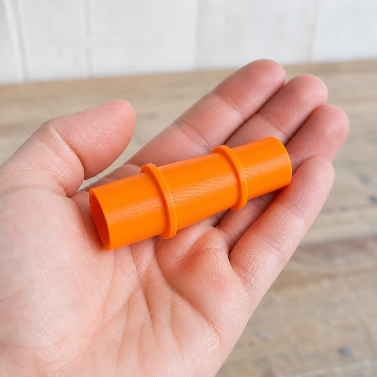 The 50-114 to 1.5" Duct dust adapter held in one hand to show its size