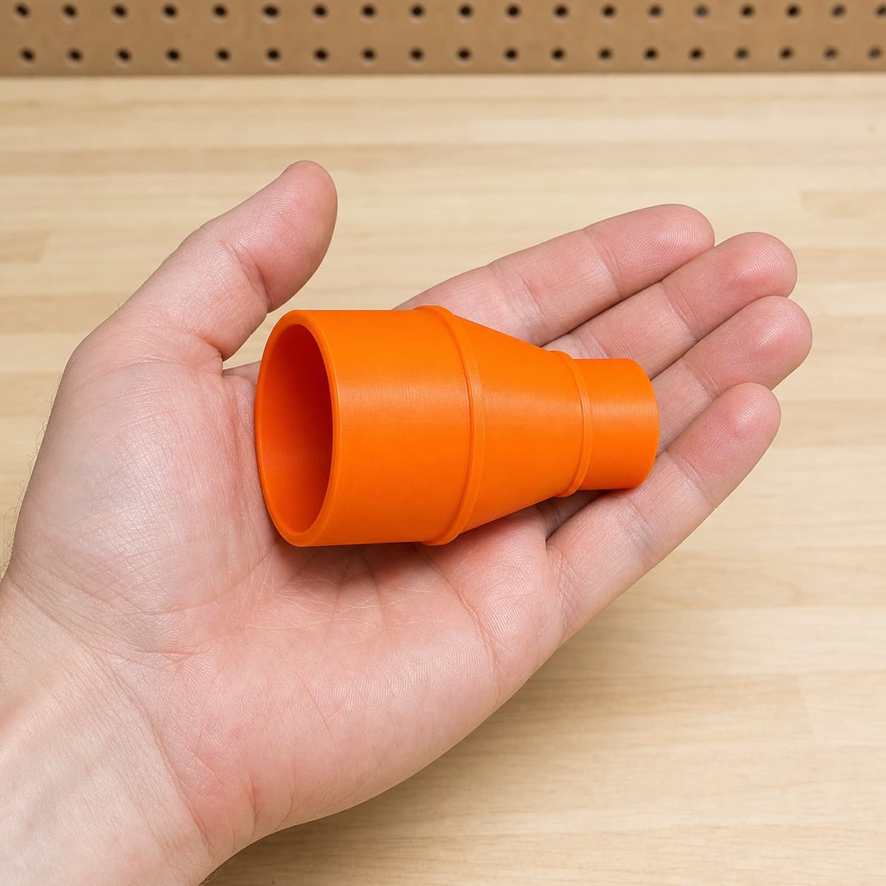 The GET75 to 2" Duct dust adapter held in one hand to show its size