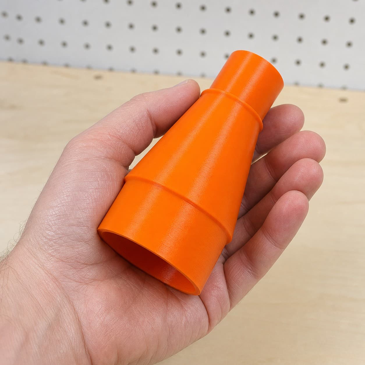 The DSP600 to 2.5" Duct dust adapter held in one hand to show its size