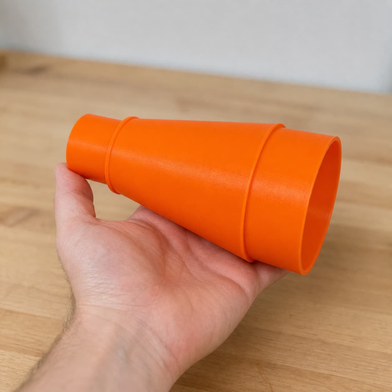 The DSP600 to 3" Duct dust adapter held in one hand to show its size
