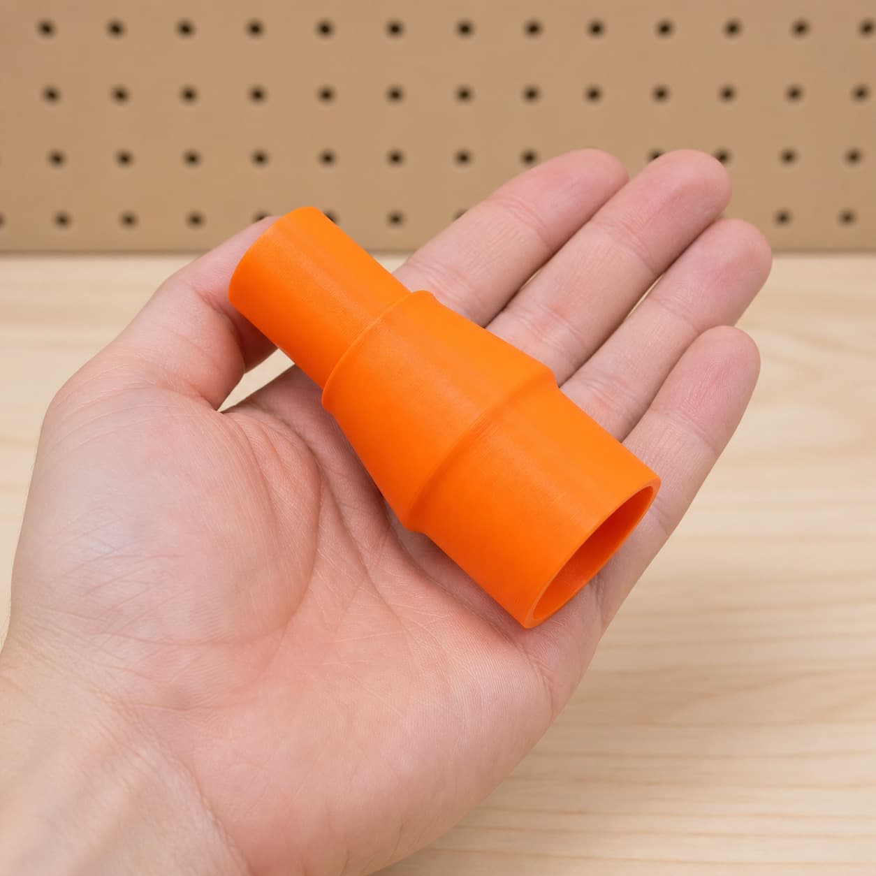 The XSH06Z to 27mm Festool dust adapter held in one hand to show its size