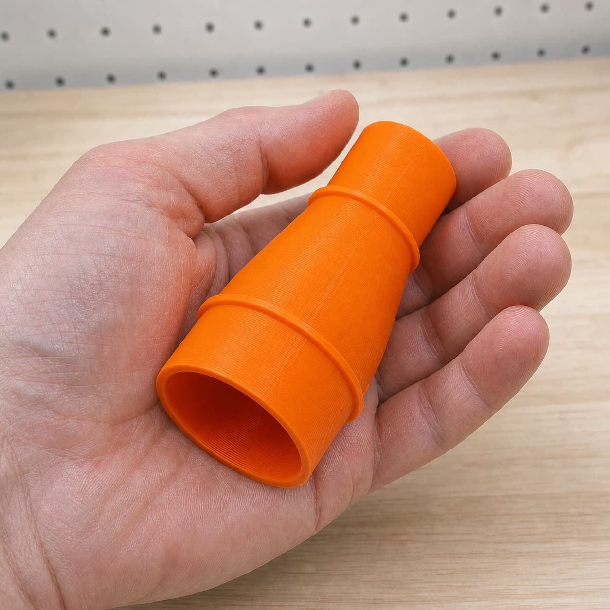 The TSS102L to M18 6G Vac dust adapter held in one hand to show its size
