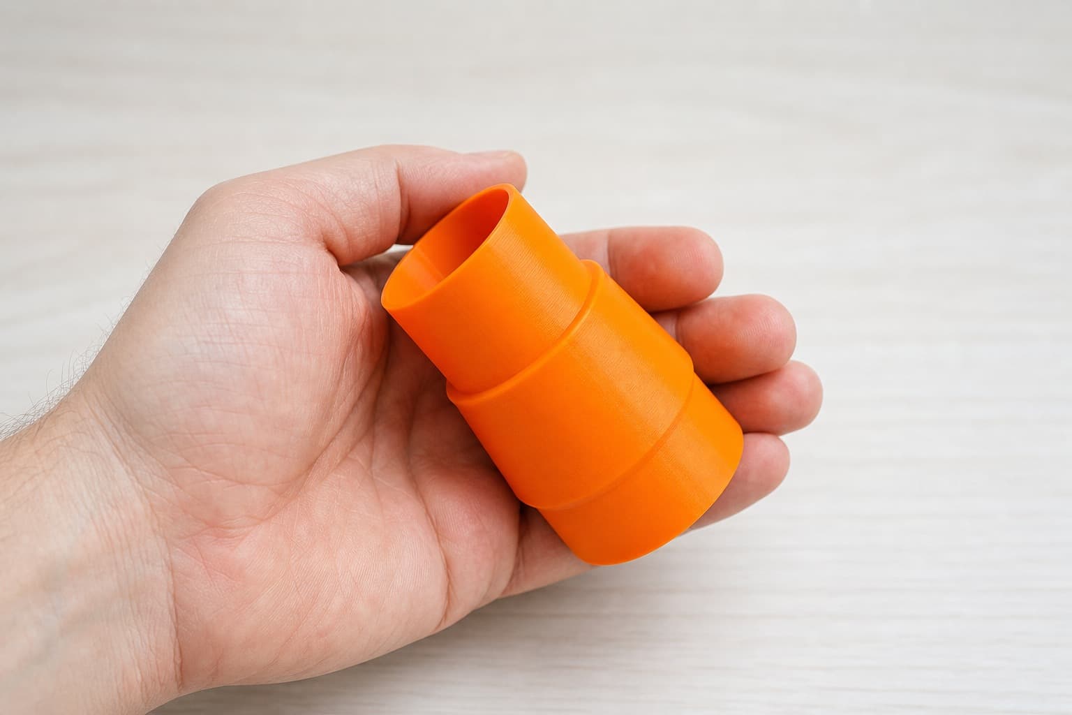 The KGS 216 M to 1.875" Shop Vac dust adapter held in one hand to show its size