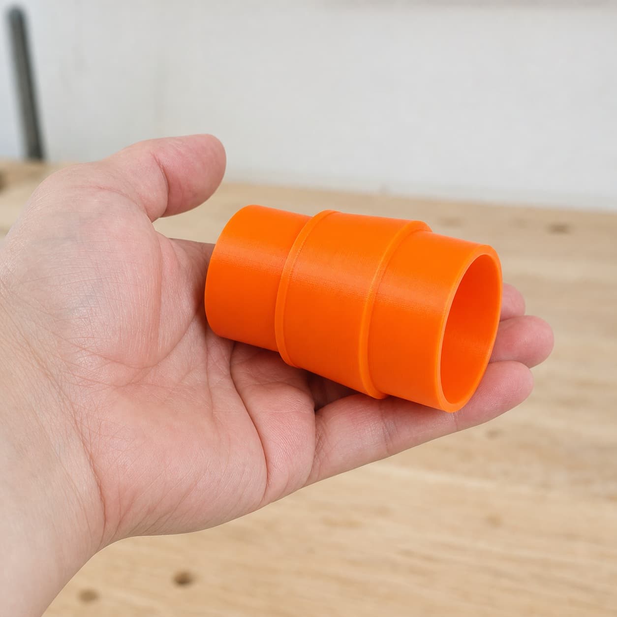 The DWE6423K to 1.875" Duct dust adapter held in one hand to show its size
