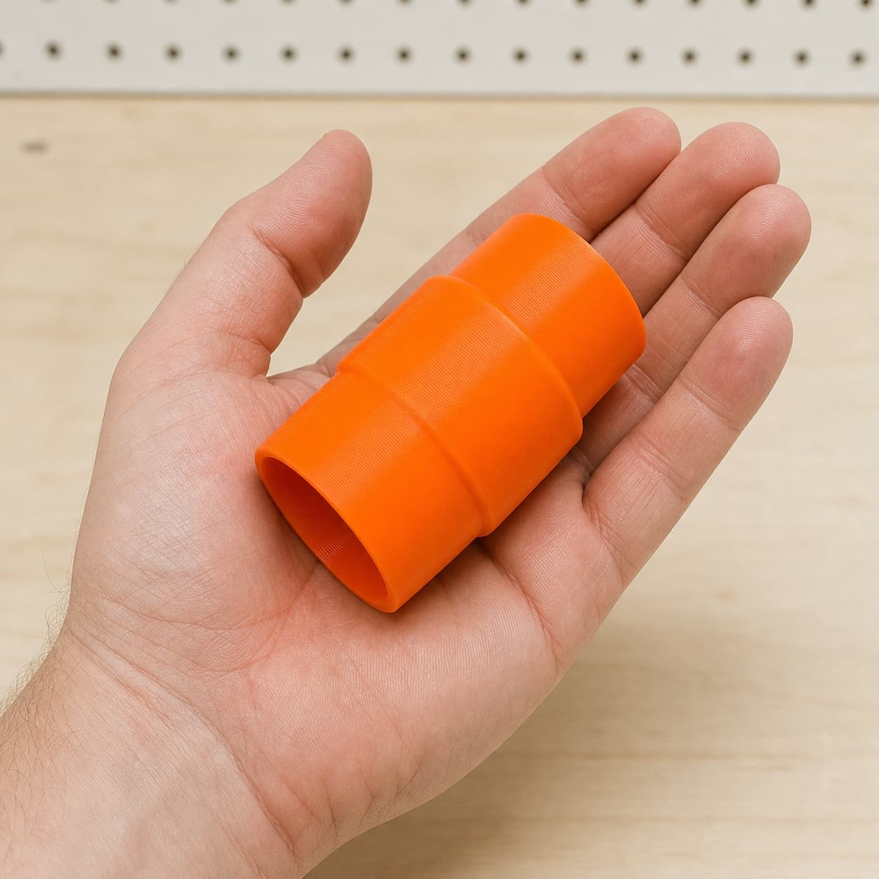 The GCM12SD to 1.875" Duct dust adapter held in one hand to show its size