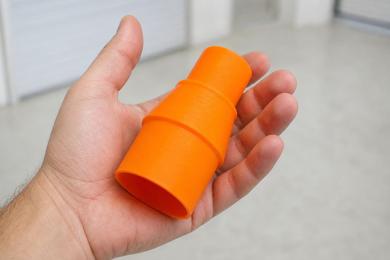 The GCM12SD to Craftsman 16G dust adapter held in one hand to show its size