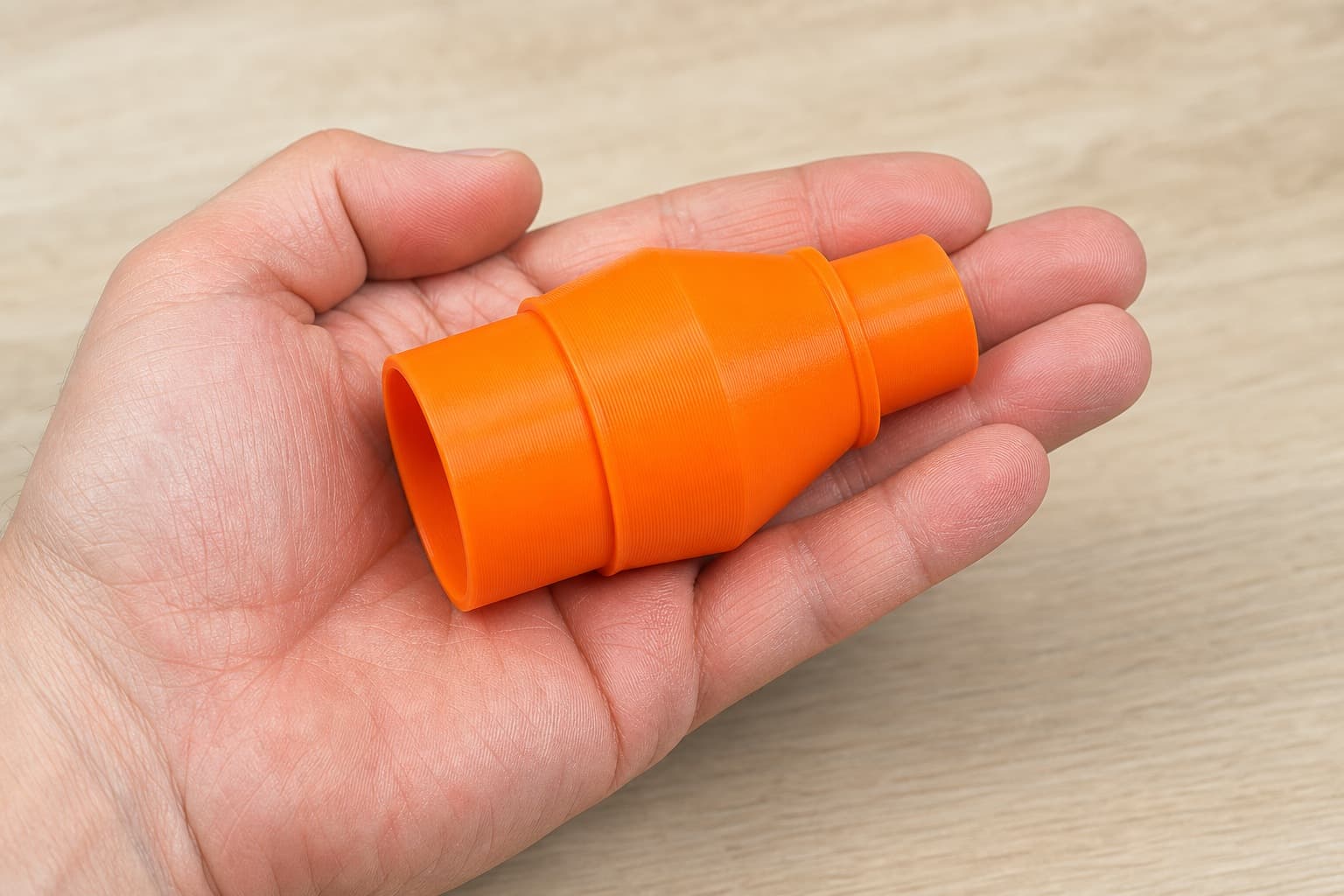 The DKP180 to 1.25" Duct dust adapter held in one hand to show its size