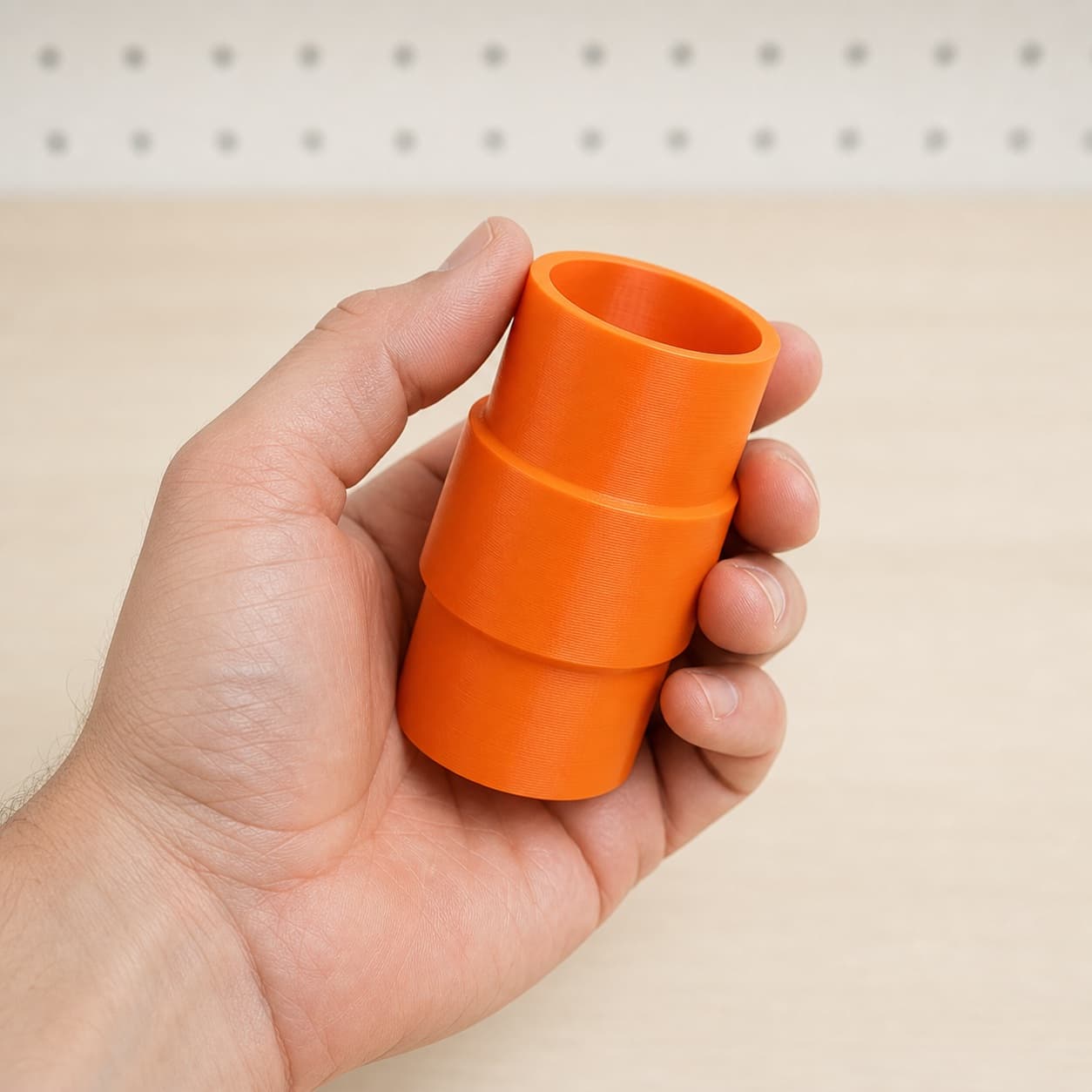 The KP0810 to Craftsman 20G dust adapter held in one hand to show its size