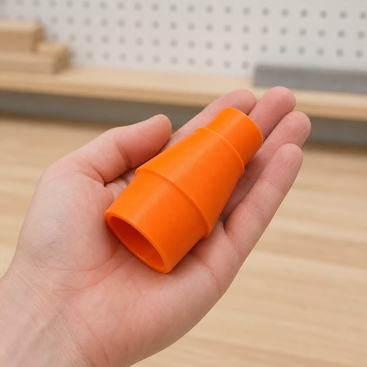 The 58862 to 1.25" Shop Vac dust adapter held in one hand to show its size