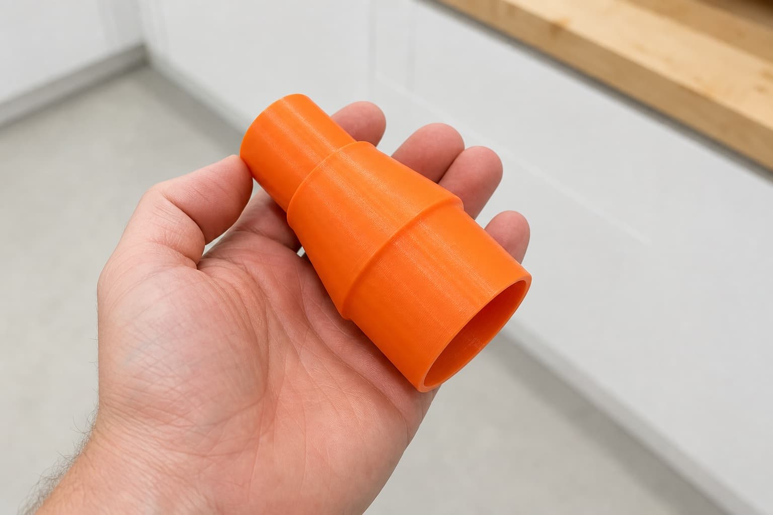 The 58862 to 36mm Festool dust adapter held in one hand to show its size
