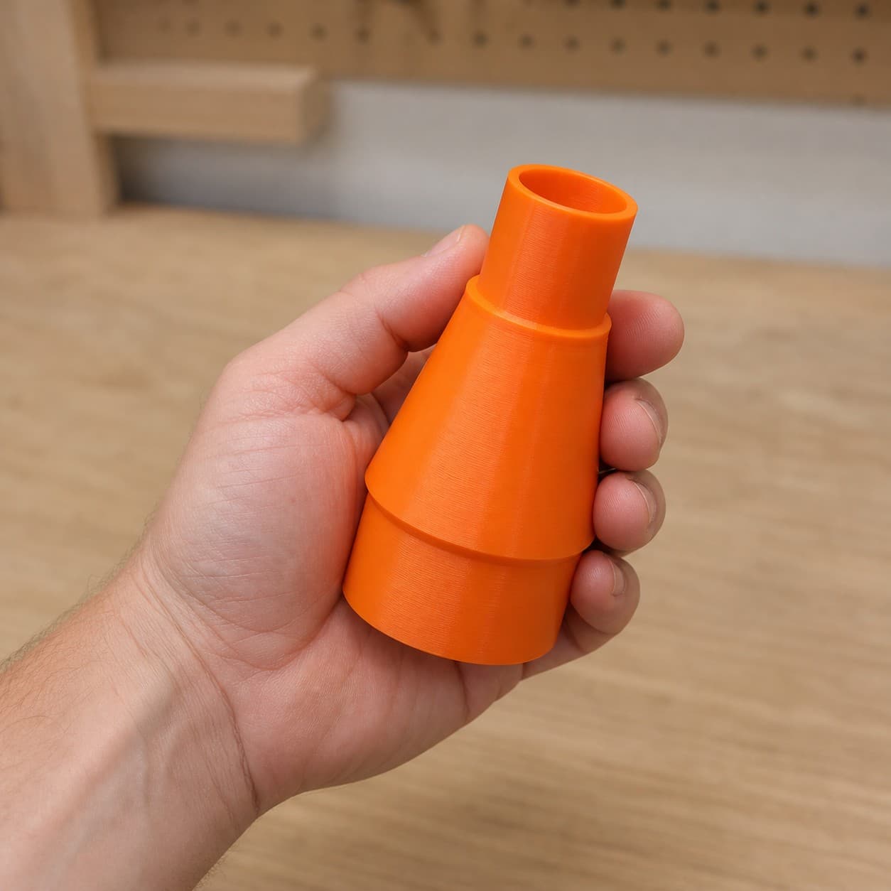 The RTS23 to 1.25" Duct dust adapter held in one hand to show its size