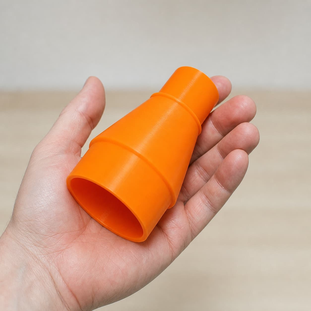 The CMXETAX to Bosch GAS18V-10L dust adapter held in one hand to show its size
