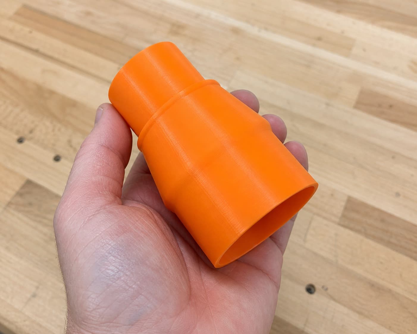The CMXETAX to 1.875" Duct dust adapter held in one hand to show its size