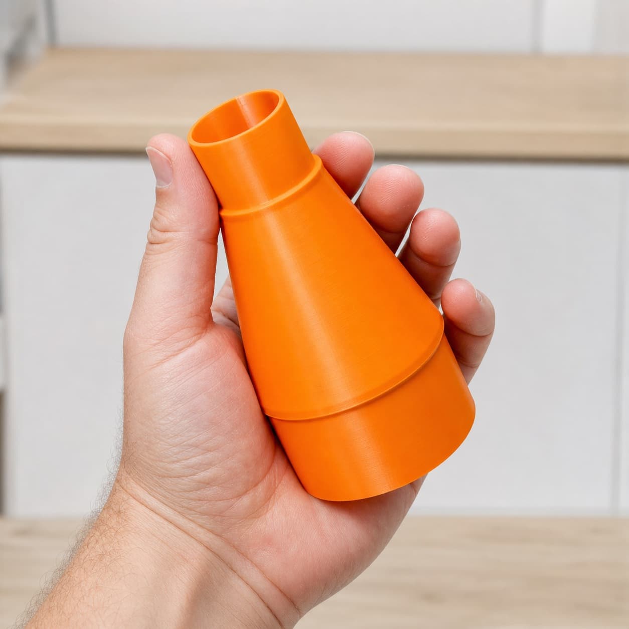 The BW9501-00 to Bosch GAS18V-10L dust adapter held in one hand to show its size