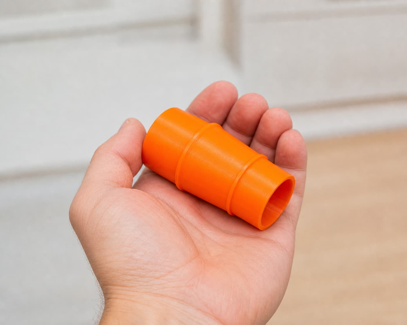 The 59313 to 2.5" Shop Vac dust adapter held in one hand to show its size