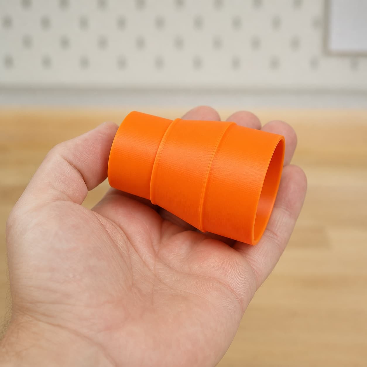 The 2012NB to Bauer 6G Vac dust adapter held in one hand to show its size